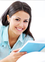 Woman lying down reading a book and smiling